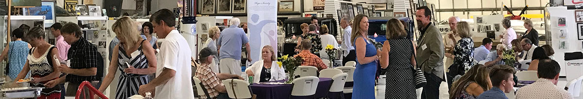 People mingling at a corporate event hosted at the Warhawk Air Museum