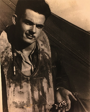 John Hoye, covered in his own blood, holding two medals.