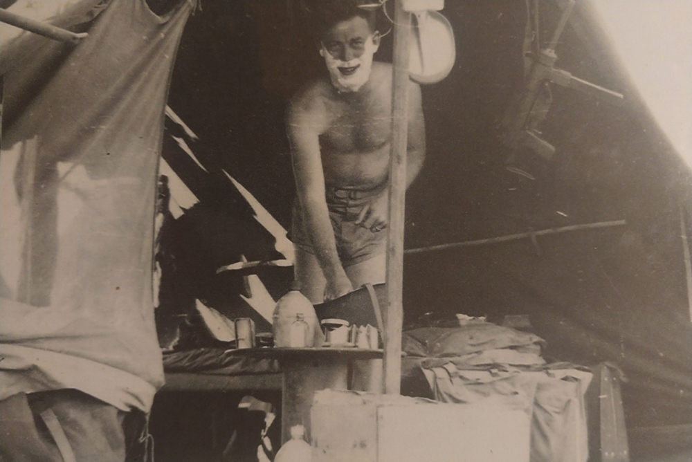 David shaving in a tent.